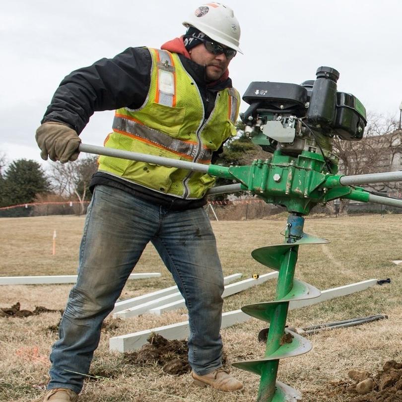 Drilling fence post holes with a power auger